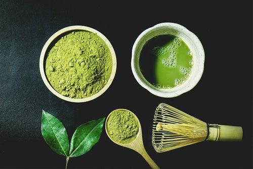 Two cups of matcha with spoon and whisk