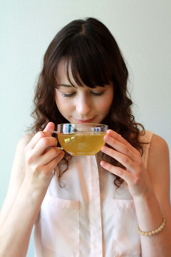
                  
                    a young lady sipping a cup of citrus lavender herbal tea
                  
                